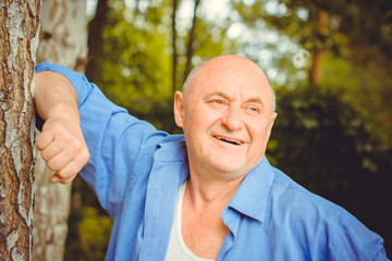 An elderly American man is joyful and cheerful enjoying life laughing and having fun outdoors in nature