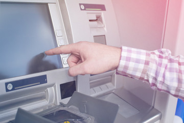Hand of a man with a credit card, using an ATM. Man using an atm machine with his credit card....