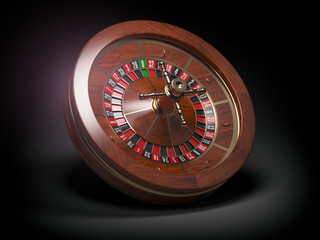 Casino roulette wheel on black background.