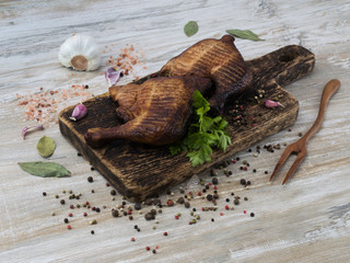 Smoked chicken legs on a wooden kitchen table. 