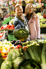 Young couple buying vegetables on a market