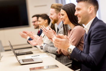 Happy smiling business team clapping hands