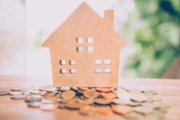 Obraz na płótnie Canvas Wood house model with coin, savings plans for housing ,financial concept, warm tone
