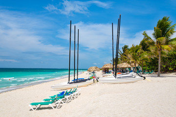 Varadero beach in Cuba with sailboats and thatched umbrellas