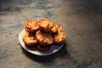White dish with muffins on a wooden background.