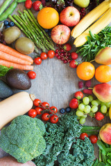 Top view of apples, bananas, berries, oranges, carrots, tomatoes, broccoli, beans, butternut squash, avocado, and asparagus, on the grey wooden table, top view, copy space for text, selective focus
