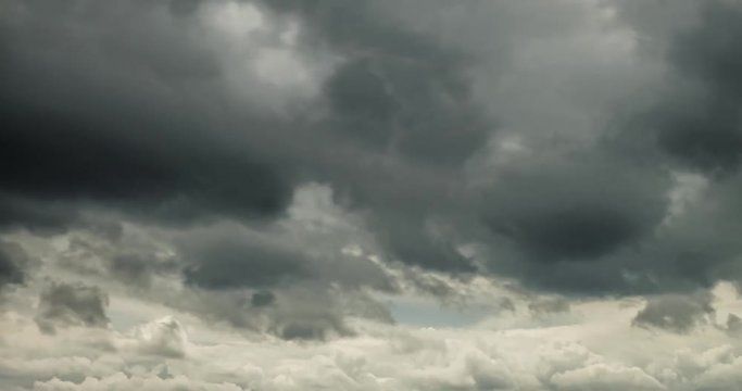 Time lapse clip of gray fluffy curly rolling clouds before storm