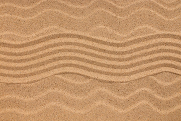 Fototapeta na wymiar Zigzag on sand and seashells on wavy sand. Conceptual image.
