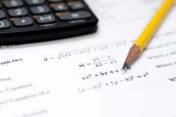 calculator and pencil isolated on a white background with mathematical formulas visible