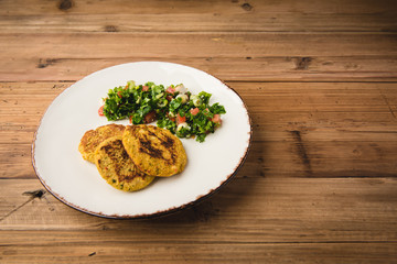 Cakes served with salad on white plate