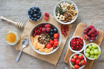 Paleo style breakfast, grain free muesli made with nuts and dried fruits, served with fresh berries, top view, selective focus