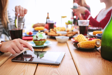 Top view of group of people having dinner together while sitting at wooden table. Food on the table. People eat fast food.