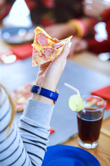 Top view of group of people having dinner together while sitting at wooden table. Food on the table. People eat fast food.