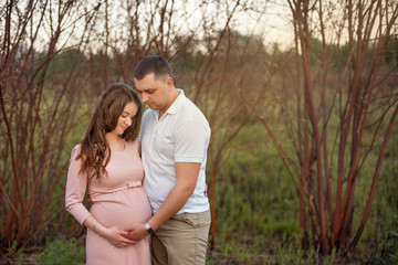 Fototapeta premium Family love couple in the forest park Woman pregnant Future parents in anticipation of the baby