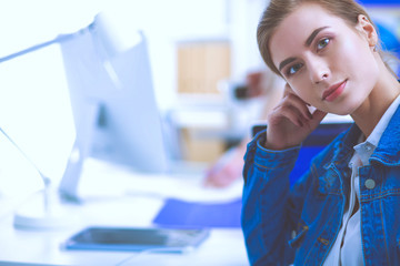 Two young woman sitting near desk with instruments, plan and laptop.