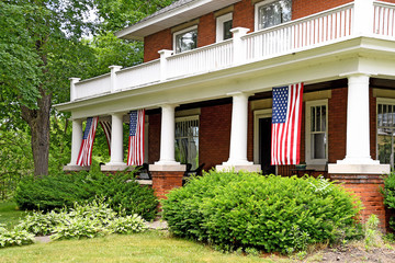 American flags hanging on house front porch
