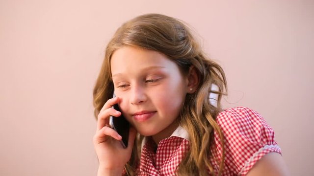 Portrait of a girl with long hair speaks on the phone at home