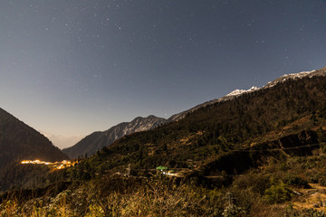 Fototapeta na wymiar Mountain with little snow on the top with stars in the night at Lachen in North Sikkim, India.