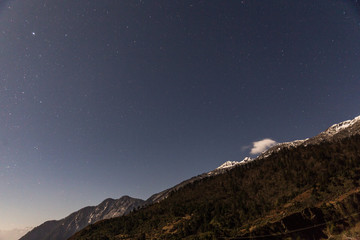 Mountain with little snow on the top with stars in the night at Lachen in North Sikkim, India.