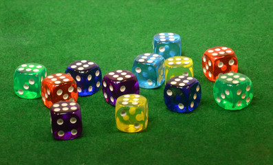 Dice in different colors on a green table.