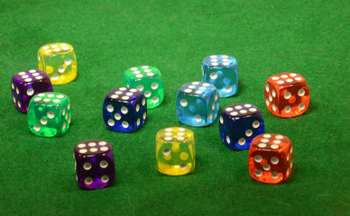 Dice in different colors on a green table.