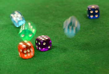 Dice in different colors on a green table.