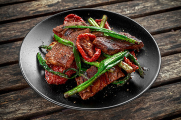 Grilled beef with vegetables, spring onion, asparagus on plate.