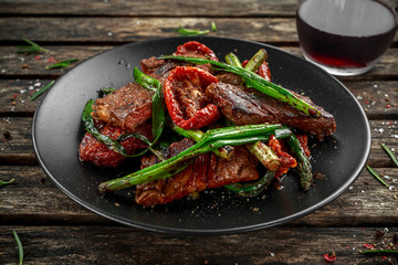 Grilled beef with vegetables, spring onion, asparagus on plate.