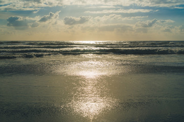 Fototapeta na wymiar Sunlit waves at the beach.