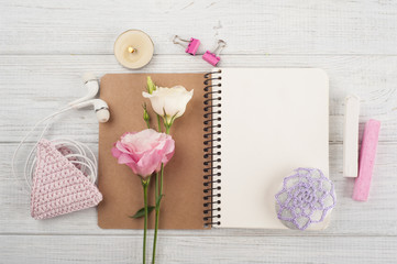 Blank notebook, pink crochet holdel, earphones