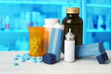 Asthma inhalers with medicines on blue background