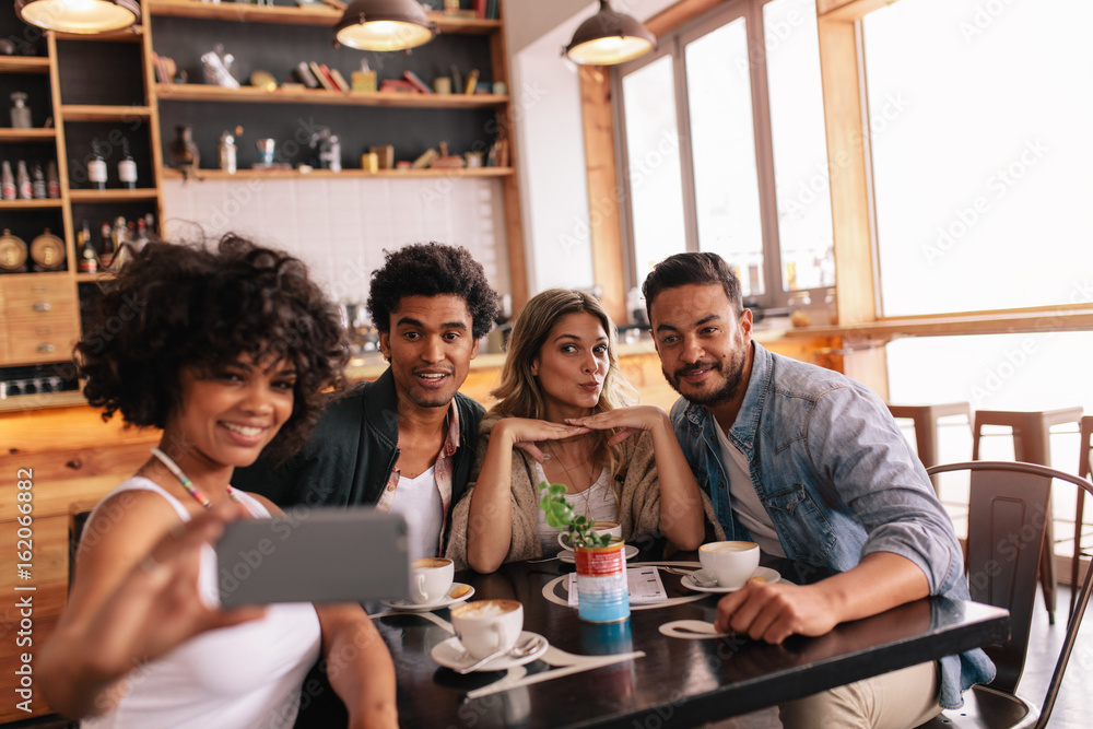 Poster Small group of friends taking selfie at cafe