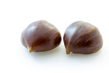 Two tasty uncooked chestnuts with white background