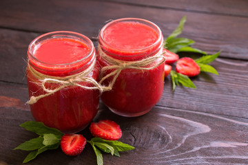 Strawberry  smoothie in the glass jars .Healthy fruits dessert on the wooden table