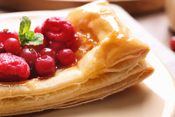 Plate with delicious pastry and berries, closeup
