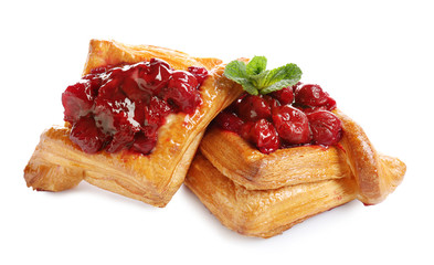 Delicious puff pastries with cherry on white background