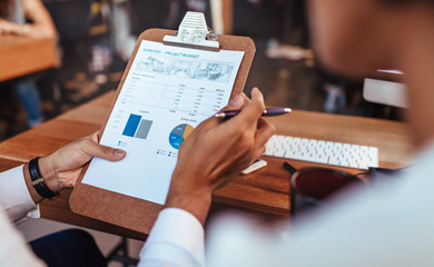 Business people analyzing statistical charts in office