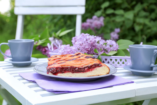 Cherry pie on table in lilac garden