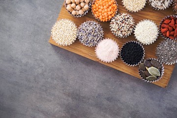 Various superfoods, seeds, cereals, grains on a gray background. Healthy eating concept. Top view
