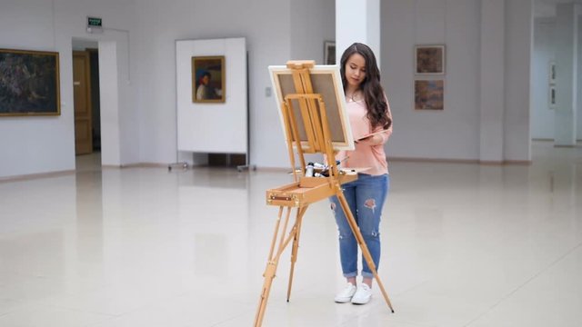 Girl painting a picture in art gallery.
