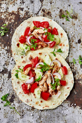 Grilled chicken and fresh vegetables salad tortilla. Healthy delicious breakfast or snack , top view. Flat lay.Outdoors Food Concept