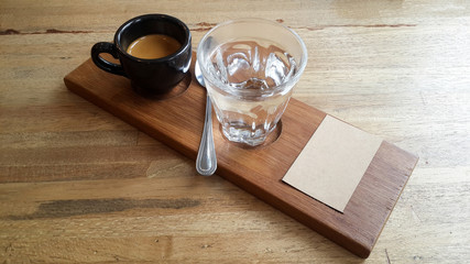 espresso coffee shot in black cup on the wooden plate with cupping note and copy space