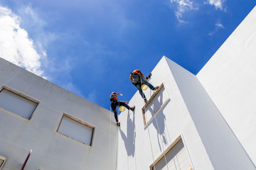 industrial alpinist work on white wall