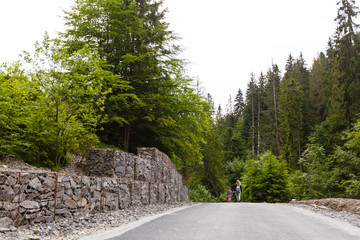 Slope and earth retention wall management with rocks and wire mesh cage system in tropical hilly terrain