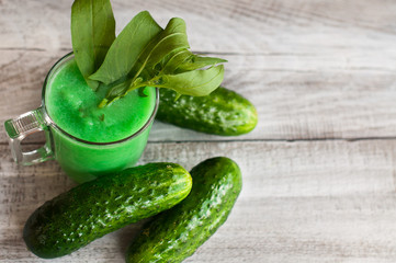 Vitamin cocktail, smoothies from cucumbers and spinach. Close-up on a wooden background.