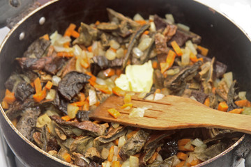 Mushrooms fried on the pan with carrot and onion
