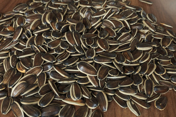 Dried unshelled sunflower seeds on a wooden table. Vegetarian food