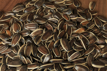 Dried unshelled sunflower seeds on a wooden table. Vegetarian food