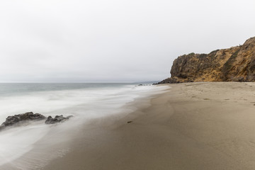 Fototapeta na wymiar Pirates Cove and Point Dume with motion blur and clouds in Malibu, California.
