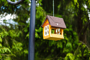 knitted from yarns birdhouse hanging in the park